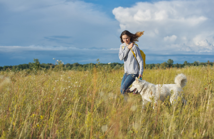 Femme avec son chien dans un champ